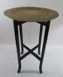 Mesa/Bandeja de metal dourado indiano ricamente cinzelado com florais, base de madeira na forma de cavalete articulado. Base adaptada. Marcado Made In India ARTIS. Med. 62 cm alt x 39 cm diâmetro.
