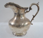 PRATA- Jarra bojuda em prata "Sterling" Silver teor 925, origem Mexicana de contraste na base. base redonda, decorada com guirlandas e alça lateral. Peso 987 gramas. Med.22 cm alt x 16 cm diâmetro. Leve mossa no bojo.