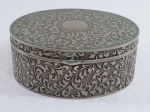 Grande caixa/ porta jóias em metal espessurado a prata no formato oval e ornamentos em volutas. Possui o interior aveludado na cor vermelha. Med. 6,5 x 16,5 x 15 cm.