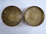 Centro de mesa e prato em metal dourado indiano, ricamente cinzelado, um decorado ao centro com figura de Fênix, um com palácio Taj Mahal e folhagens em guirlandas. Meds. 19,5 cm diâmetro e 20 cm diâmetro.