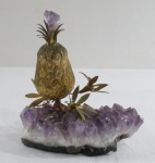 Escultura de " Abacaxi" em metal dourado com base em gusa de pedra ametista. Med. 15 x 12 x 7 cm.
