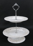 Fruteira alta de dois estágios, em porcelana branca moldada na pasta ,base em metal prateado. Med. 29 x 21 cm. ;