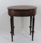 Mesinha de cabeceira em jacarandá, quatro pés, coluna frisadas encimada por gaveta e tampo oval. Med. 57 x 47 x 29 cm. Vendida no Estado.
