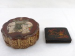 Duas (02) antigas caixas em laca sendo uma retangular decorada com guerreiros ( 3 x 12 x 10 cm), uma redonda decorada com guirlandas e tampa com elefante em madrepérola em relevo ( 8 x 18 cm). Ambas com perdas, vendidas no estado.