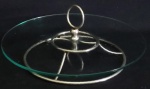 Belíssimo centro de mesa/ petisqueira, em formato circular em metal espessurado a prata e vidro translúcido, próprio para frios. Med.:10x30cm.