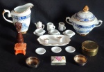 Lote constando vinte peças, em porcelana branca vitrificada, sendo uma leiteira e um açucareiro com rica pintura na tonalidade azul com frisos na tonalidade dourada da marca Porcelana Real, uma figa confeccionada em madeira, treze peças em porcelana de tamanho miniatura e quatro na tonalidade ouro velho. Med. tamanhos variados.