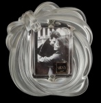 Lindo e antigo porta retrato, confeccionado em  vidro no estilo de Renê Lalique, moldado em peça única na forma de laço.  Med:14x16cm.