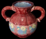 Belíssimo vaso bojudo, confeccionado em faiança, ricamente esmaltado na tonalidade bordo e azul, pintura representando flores e folhas, com duas alças laterais .Med:26x31cm.