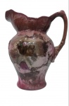 ANTIGUIDADE - Imponente jarra de batismo em faiança, na tonalidade rose, com rica pintura representando fase feminina e fina decoração de arabesco em relevo no seu bojo. Med:30x14cm. (observação está  com marcas do tempo).