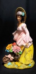 CAMPONESA - Elegante, imponente e antigo grupo escultórico europeu, ao gosto art nouveau, anos 50, em porcelana pintada a mão, representando Cena de Camponesa Com Carrinho de Flores. Med 42x25x18 cm.