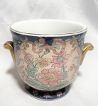 Elegante e rara floreira, ao gosto barroco, anos 50, em porcelana finamente policromada, realçada a ouro, com decoração Floral. Med 13x19 cm.