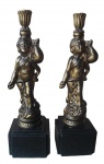 Magnífico par de Castiçais Italianos, em bronze artístico, cinzelado, repuxado, no estilo barroco, apresentando Esculturas, pátinas douradas. Medindo 43 cm de altura. Apoiadas em bases de mármore preto belga