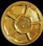 Grandiosa petisqueira em metal dourado, com seis divisórias, bordas decorada em relevo. Med: 48 x7cm.