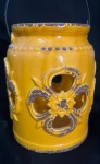 Vaso de cerâmica, na tonalidade amarela, decorado por flores vazadas em seu bojo. Med: 19,5 x15cm.
