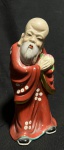 ARTE ORIENTAL - "Shou Xing" Imponente e antiga escultura chinesas, ao gosto dinastia Ching, anos 50, em porcelana finamente esmaltada a mão realçada a ouro, representando Cena de Deus da Longevidade Com Criança. Med 22 cm. Obs: Apresenta lascado. As representações artísticas geralmente retratam Shouxing como um velho barbudo, com sobrancelhas altas e um cajado torto em uma das mãos. Ele segura o pêssego da imortalidade na outra mão. Uma cegonha ou tartaruga é frequentemente acrescentada como mais um símbolo de longevidade, que os chineses consideram uma bênção especial.