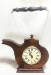 RUBINICK - Elegante e antigo relógio de parede/mesa, Arte Deco, anos 50, a corda, com caixa em madeira nobre ricamente entalhada, representando Chaleira. Med 36x27 cm. Obs: maquina no estado. apresenta discretas marcas do tempo.