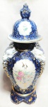 Lindíssimo e raro potiche, no estilo francês, ao gosto art nouveau, anos 40, em porcelana nas cores branco e azul, magnificamente policromada, realçado a ouro, decorado por  Flores e Cariátides. Pega da tampa representando Pinha. Med 40x18 cm.