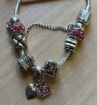 PULSEIRA PRATEADA COM  VARIOS ADORNOS COM EXIBIDA NA FOTO BÉLISSIMA!!!