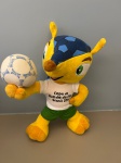 Boneco Fuleco mascote da copa do Mundo fifa 2014, no Brasil. Ele é representado como um tatu bola uma espécie nativa do Brasil que se enrola e se transforma em uma bola quando se sente ameaçado. Boneco de pelúcia.
