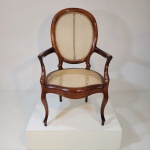 Belíssima cadeira de braço antiga, executada em madeira nobre maciça e com palhinha sintética. Medin