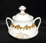 SCHMIDT- Belíssimo açucareiro produzido em porcelana, com linda ornamentação de filetações em ouro represnetando arabescos e volutas, seguida de trigo da fortuna, maior comprimento:7cm.