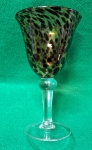 Taça de vinho feita de vidro soprado à mão com um padrão que lembra casco de tartaruga em tons de marrom. A taça possui uma base aplicada e tem cerca de 20 cm de altura