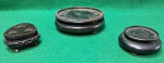 Lote com 3 pequenas peanhas em madeira, sendo;  da esquerda  com três reentrâncias circulares no topo e entalhes decorativos nas laterais;  do meio com o topo plano e uma borda levemente elevada e a da direita é o menor dos três, também com borda, mas mais básico no design. Usados e em muito bom estado.