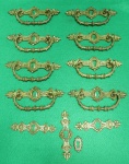 Lote com 12 peças em metal dourado para gavetas de móveis antigos. O lote consiste em 8 puxadores e 4 acabamentos de fechadura, todos ornamentados com estilo floral em muito bom estado. Os puxadores medem 14cmC x 4cmL