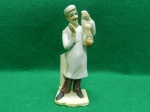 Estatueta de porcelana retratando médico segurando recém nascido. Porcelana pintado a mão. Arnart Papide Benni. Usado. em muito bom estado. Sem lascados, quebras ou trincados. Mede 15 A x 5 C x 4 L