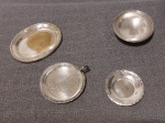 Lote composto por 4 peças banhadas à prata, sendo uma pequena palmatória, decorada com gravação em motivos florais, medindo 8,5 cm diâmetro e 3 salvas tendo a maior 11 x 8 e a menor 7,5 cm diâmetro.