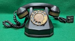 Telefone analógico de baquelite, sem marca aparente, anos 40, conhecido como "Tanque", tendo em vista sua aparência robusta. Sem quebras ou trincas. Aparenta estar com todo seu mecanismo interno. Não está adaptado para uso atual. Necessita limpeza geral.