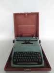 MAQUINA DE ESCREVER - OLIVETTI: Antiga e bonita maquina de escrever da marca OLIVETTI modelo STUDIO 44, em alumínio fundido pintado de verde, com caixa em madeira, precisa de revisão nas teclas, medidas da caixa: altura:20 cm, largura:37 cm e profundidade:42 cm