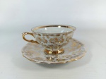 PORCELANA - BARCUTHER: Antiga xícara de café com píres executado em porcelana na tonalidade branca rico em detalhes dourados, "BARCUTHER WALDSASSEN BAVARIA", medidas: XÍCARA: altura:5 cm e PÍRES: siâmetro:12 cm