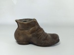PORTA CANETAS - BOTAS: Suporte de canetas de mesa executado em resina representando uma bota, capacidade para quatro canetas. Medidas: altura: 6 cm, largura: 6 cm e comprimento: 13 cm.