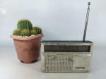 RÁDIO - GRUNDIG: Antigo rádio portátil da marca Grundig modelo Mini Boy 400, com a frente em alumínio, com duas faixas, não está ligando. Medidas: altura: 10 cm, largura: 15 cm e profundidade: 3 cm