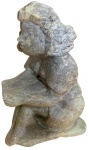 Escultura de uma menina sentada lendo um livro, feita em pedra sabão. Assinado e datado PERSEU 1996
