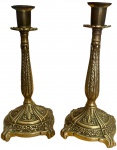 Lote composto por gracioso par de castiçal em bronze, decorados por detalhes em relevos. Mede 20cm.