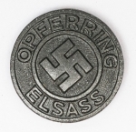 Militaria Alemanha - II Guerra - O partido nazista promoveu uma grande arrecadação de fundos antes e durante a guerra com a venda de pins, pendentes, tinnies, badges e etc - Todos colecionáveis para incentivar a compra constante. Adquirimos em Ciney, Bélgica, feira de militaria, uma grande coleção desses itens, todos originais, muitos catalogados no livro Donation Badges, Pins & Pendants of the Third Reich de Joseph Cassidy & Christopher Alexander. Oportunidade para colecionador avançado 
Item não promove ou glorifica violência ou intolerância racial. Está à venda apenas para fins de preservação da memória histórica. Organização do leilão não faz apologia a quaisquer movimentos políticos ou ideológicos, e repudia qualquer ideologia de cunho racista. Pin - Opferring Elsass - 23mm - Fabricante R. Hauschild Pforzheim - Raríssimo, alta cotação