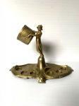 Porta Licor de metal revestido de dourado decorado com figura feminina ao centro. Base com avarias. Exemplar possivelmente de origem européia. Dimensões: 25 cm x 30 cm x 20 cm.
