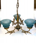 Antigo lustre de bronze para três lâmpadas ricamente decorado. Cúpulas de vidro na cor azul. Necessitando de ajustes. Acompanha canopla e corrente. Dimensões: 37 cm x 44 cm. (Medida sem a corrente).
