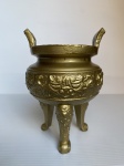 Incensário trípode oriental feito de metal, revestido de dourado, decorado com arabescos em alto relevo. Sinais de desgaste. Dimensões: 15,5 cm x 11 cm x 10 cm.