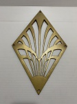 Adorno no formato geométrico de metal revestido de dourado. Dimensões: 22 cm x 34 cm.