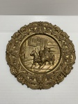 Medalhão de metal revestido de dourado decorado com cena romana. Dimensões: 29 cm / 1,5 kg.