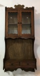 Antiga e delicada estante de parede em madeira com prateleira, porta de vidro e 2 gavetas na parte inferior. Exemplar em excelente estado. Dimensões: 99 cm x 44 cm x 18 cm.