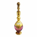 Elegante e antiga garrafa para licor em vidro veneziano na tonalidade cereja, com farta douração em ouro brunido e aplicações de flores em esmalte. Ricos detalhes em relevo. Pequenos desgastes na douração na parte da tampa. Dimensões: 32 cm altura.