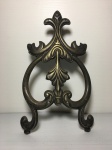 Adorno em metal cinzelado com rasquícios de banho de prata, decorado com volutas e folhas de acanto. Dimensões: 20 cm aproximadamente.