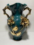 Antigo vaso de cerâmica esmaltada na cor verde, decorado com arranjos florais dourados em alto relevo. Apresenta pequenos bicados na base e parte faltando em uma flor. Dimensões: 30 cm altura.