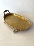 Antiga bandeja de bronze, ricamente decorada com volutas, apoiada por quatro pés. Dimensões: 35 cm x 21 cm x 7 cm.
