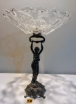 Elegante fruteira de pé alto original da década de 50, com haste ornamentada por figura de dama antiga encimada por bojo translúcido com bordas recortadas sobre base rendilhada e ricamente cinzelada com detalhes de rocalhas e arabescos em relevo. Med 41cm alt x 32cm diâm.