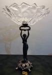 Elegante fruteira de pé alto original da década de 50, com haste ornamentada por figura de dama antiga encimada por bojo translúcido com bordas recortadas sobre base rendilhada e ricamente cinzelada com detalhes de rocalhas e arabescos em relevo. Med 41cm alt x 32cm diâm.